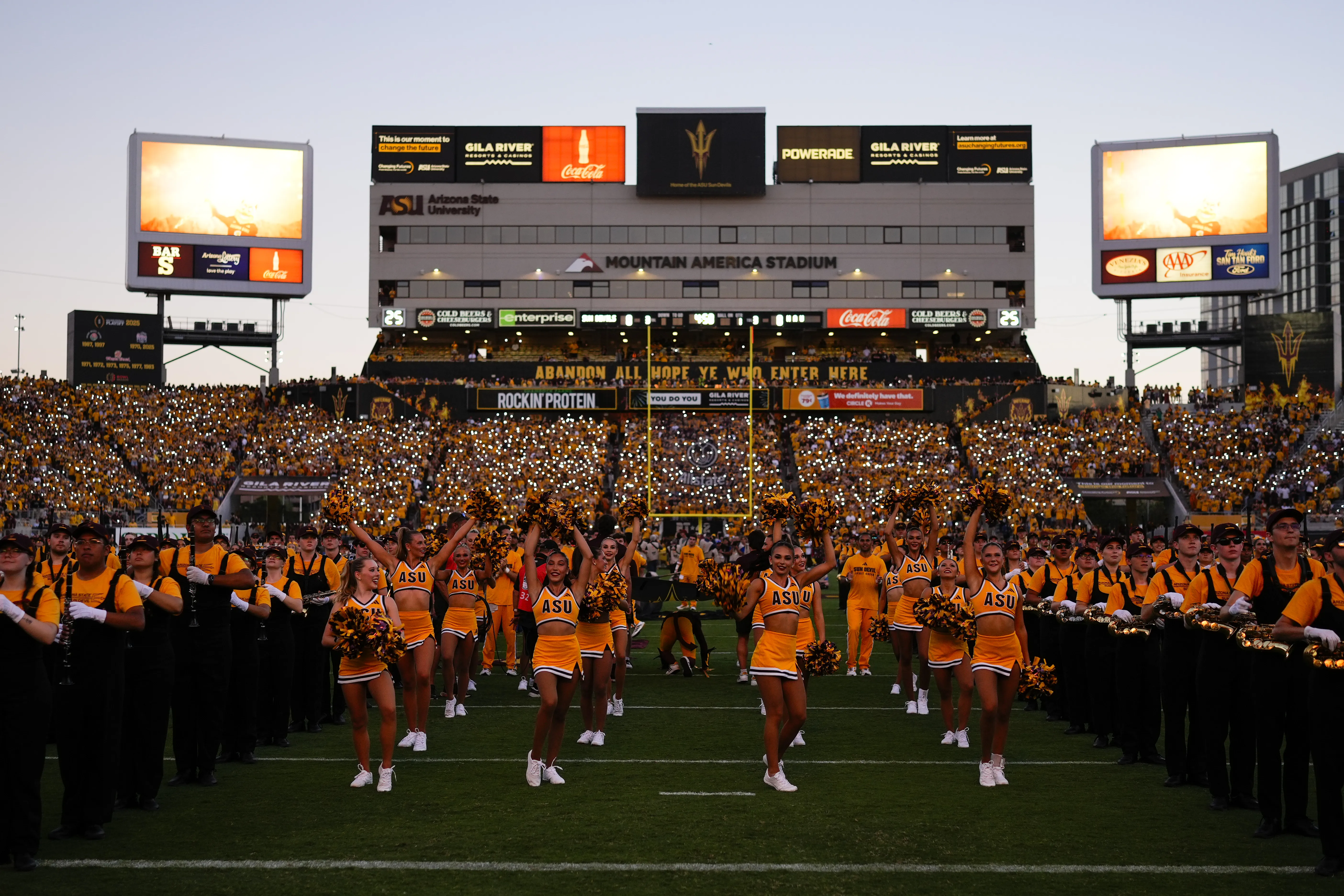 Mountain America Stadium at sunset with the band and spirit squad on the field