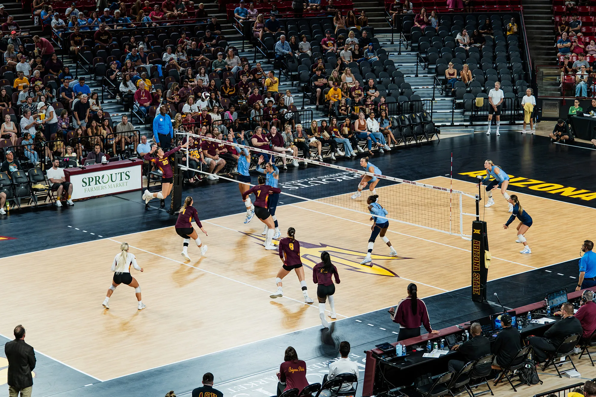 The volleyball court from up high with two teams playing.