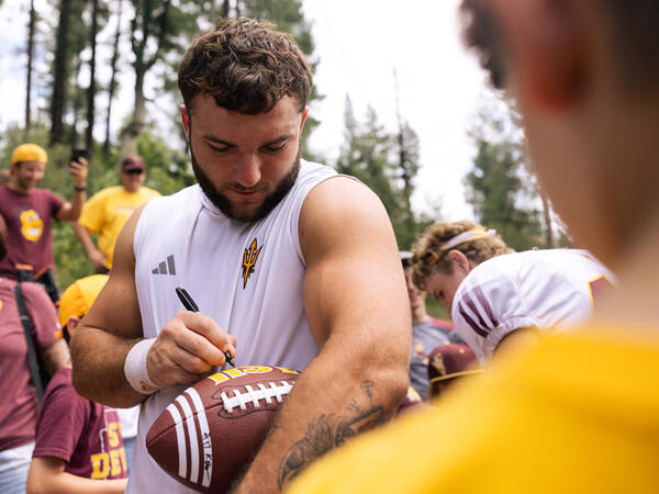 Sun Devil Football player signing football at camp