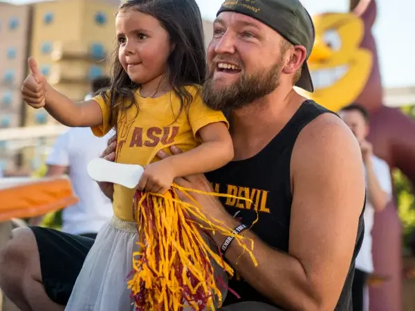 Smiling dad and daughter dressed in ASU Sun Devil gear