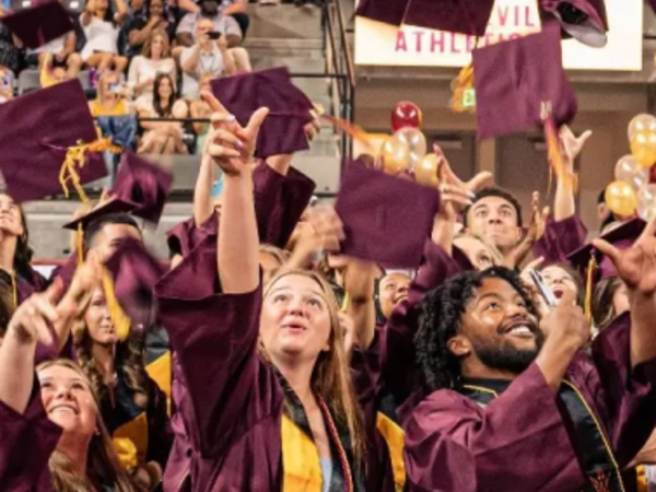 ASU Graduates throwing cap in the air 